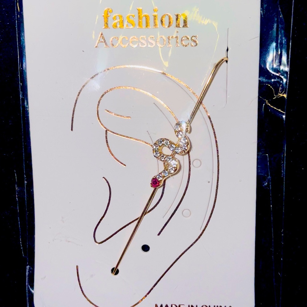 Snake design earring that’s gold color with diamonds and a ruby.
